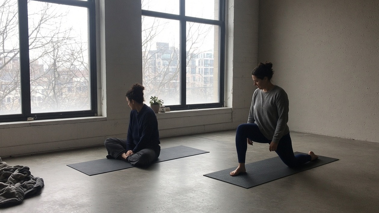 Two people on mats, one in a lunge, one sitting toward the window